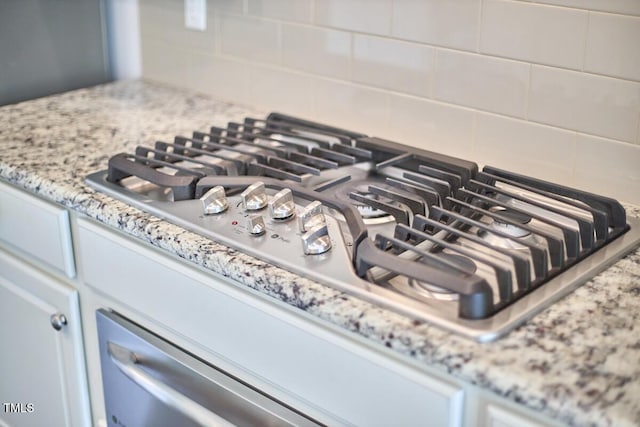 2916 Reynolda Cir, Durham, NC 27712 - kitchen view of stainless steel gas stovetop, backsplash, and light stone counters