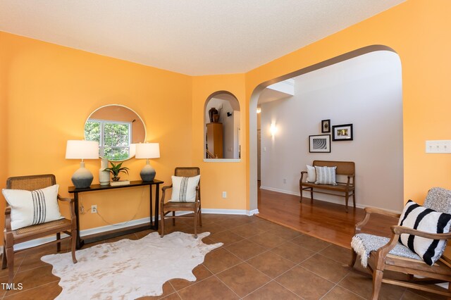 5501 Southern Cross Ave, Raleigh, NC 27606 - sitting room featuring arched walkways, tile patterned floors, and baseboards