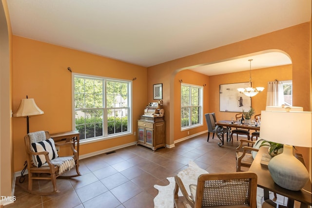 5501 Southern Cross Ave, Raleigh, NC 27606 - living area featuring arched walkways, a chandelier, baseboards, and dark tile patterned flooring