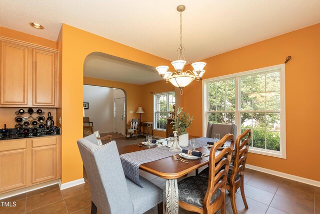 5501 Southern Cross Ave, Raleigh, NC 27606 - dining space with arched walkways, dark tile patterned floors, a chandelier, baseboards, and recessed lighting
