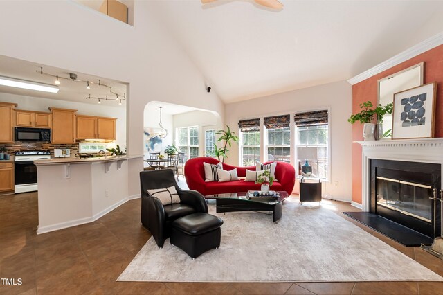 5501 Southern Cross Ave, Raleigh, NC 27606 - living area with dark tile patterned flooring, a glass covered fireplace, high vaulted ceiling, baseboards, and a ceiling fan