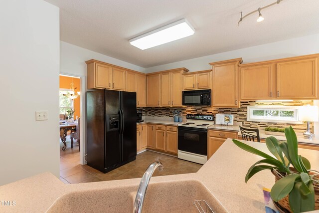 5501 Southern Cross Ave, Raleigh, NC 27606 - kitchen with black appliances, light countertops, decorative backsplash, and light tile patterned floors