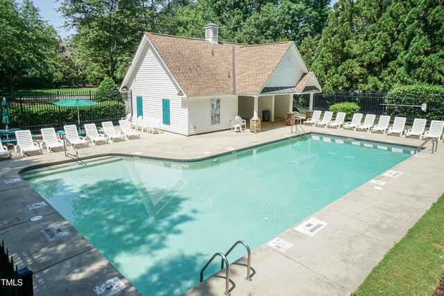 5501 Southern Cross Ave, Raleigh, NC 27606 - community pool featuring a patio area and view of wooded area