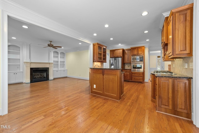 1010 Mill Pointe Way, Elon, NC 27244 - kitchen with stainless steel appliances, brown cabinets, a ceiling fan, crown molding, and light wood-style flooring