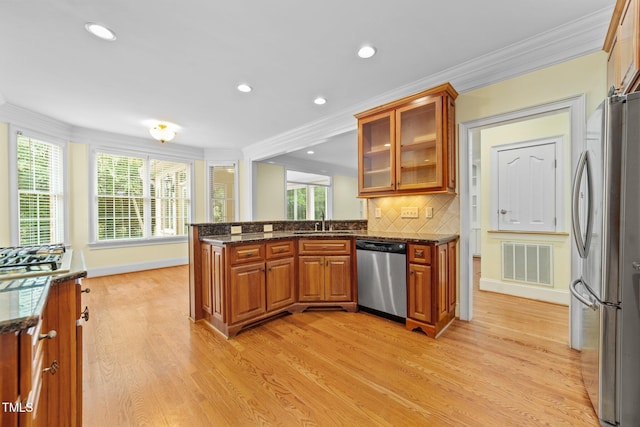 1010 Mill Pointe Way, Elon, NC 27244 - kitchen with stainless steel appliances, crown molding, brown cabinetry, a sink, and light wood-type flooring