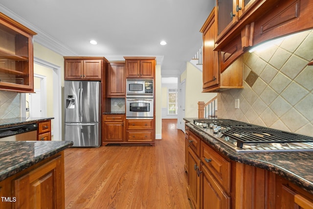 1010 Mill Pointe Way, Elon, NC 27244 - kitchen with stainless steel appliances, decorative backsplash, crown molding, dark stone countertops, and light wood finished floors