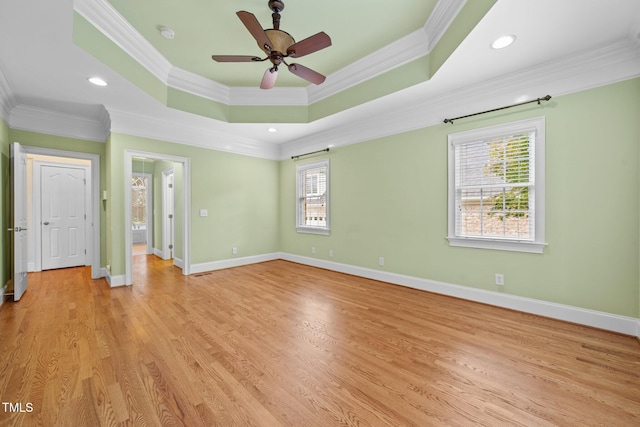 1010 Mill Pointe Way, Elon, NC 27244 - empty room featuring ornamental molding, a ceiling fan, a tray ceiling, light wood-style flooring, and baseboards