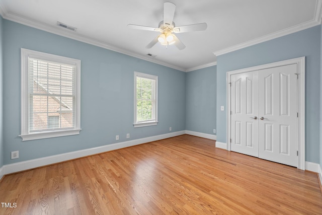 1010 Mill Pointe Way, Elon, NC 27244 - unfurnished bedroom featuring light wood-style flooring, baseboards, crown molding, and a closet