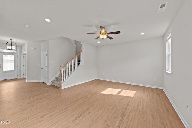 unfurnished living room with stairs, light wood-style flooring, healthy amount of natural light, ceiling fan, and recessed lighting