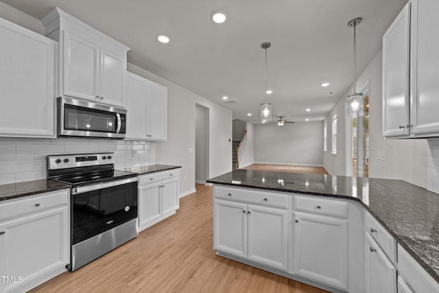 kitchen featuring appliances with stainless steel finishes, backsplash, light wood-style floors, ceiling fan, and white cabinets
