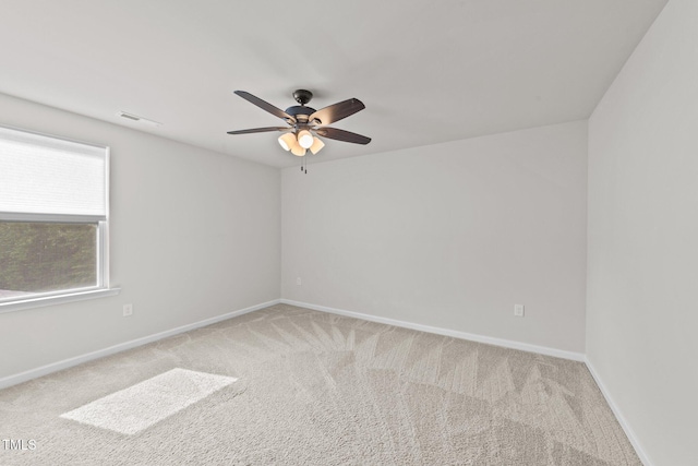 carpeted empty room with ceiling fan and baseboards