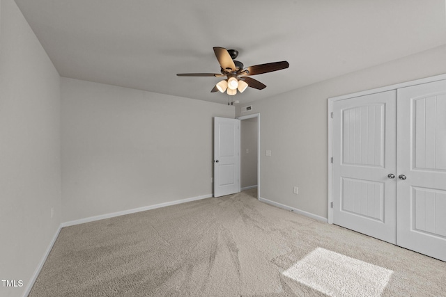 unfurnished bedroom with carpet floors, baseboards, a closet, and a ceiling fan