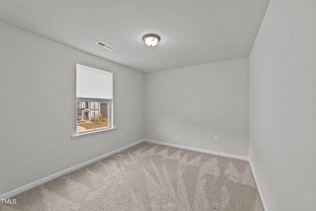 carpeted spare room featuring baseboards