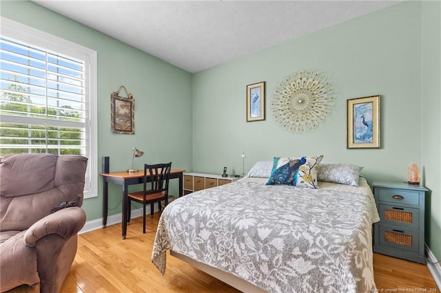 bedroom with light wood-style flooring and baseboards