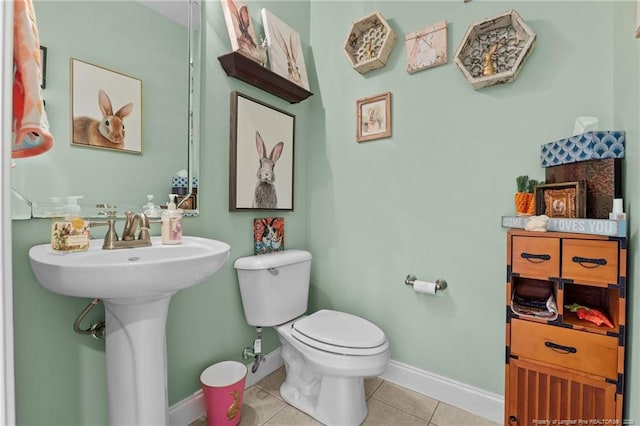 bathroom with tile patterned flooring, toilet, and baseboards