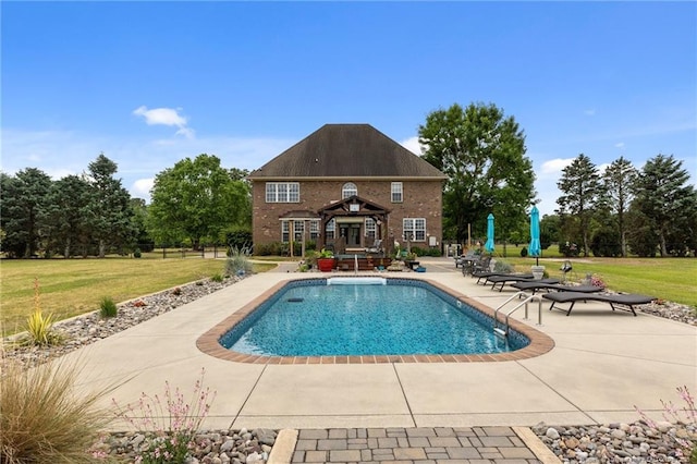 outdoor pool featuring a patio area, a lawn, and an outdoor structure