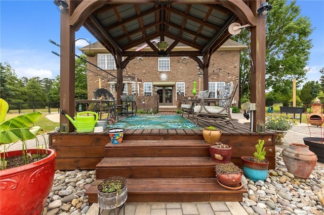 wooden deck featuring french doors, a gazebo, and fence