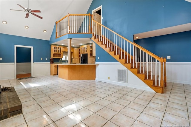 3229 Mcqueen Rd, Red Springs, NC 28377 - unfurnished living room featuring high vaulted ceiling, a ceiling fan, light tile patterned flooring, stairway, and wainscoting