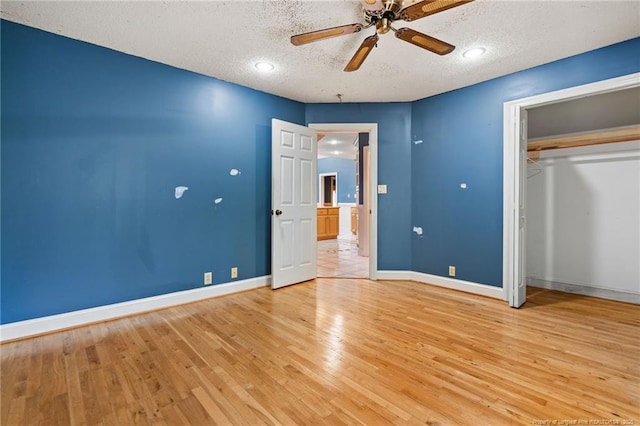 3229 Mcqueen Rd, Red Springs, NC 28377 - unfurnished bedroom with a textured ceiling, light wood-style flooring, baseboards, a closet, and a ceiling fan