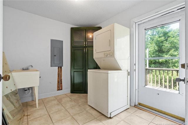 3229 Mcqueen Rd, Red Springs, NC 28377 - laundry area featuring estacked washer and dryer, electric panel, light tile patterned floors, and cabinet space