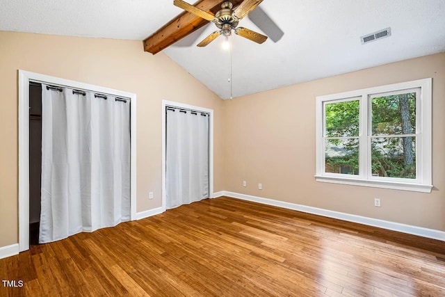 200 W Woodcroft Pkwy Unit 52A, Durham, NC 27713 - unfurnished bedroom with multiple closets, wood-type flooring, and a ceiling fan