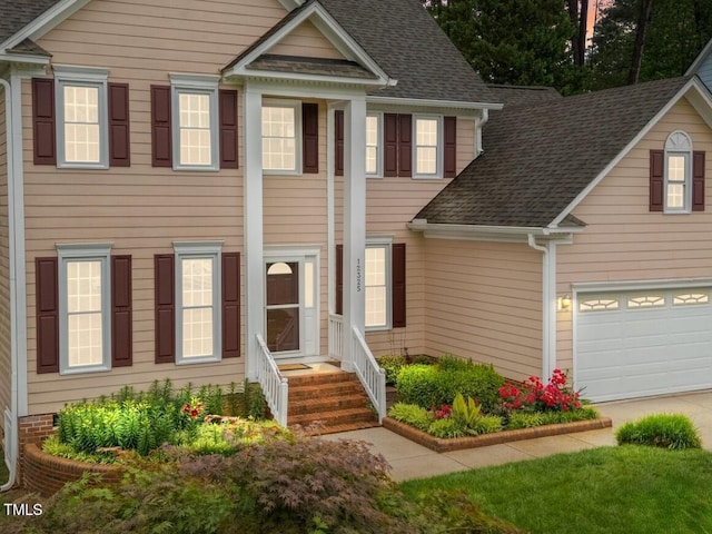 view of front of house featuring a shingled roof and concrete driveway