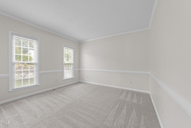 carpeted empty room with ornamental molding, plenty of natural light, baseboards, and a textured ceiling