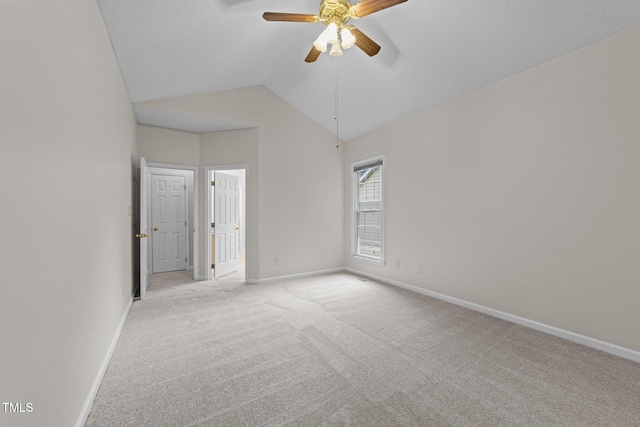 unfurnished bedroom with light colored carpet, baseboards, and vaulted ceiling