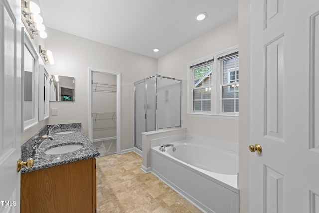 full bath featuring a shower stall, a garden tub, a walk in closet, double vanity, and recessed lighting