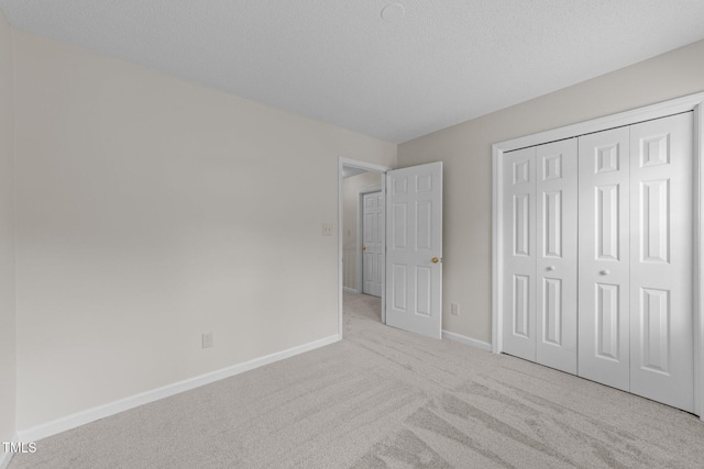 unfurnished bedroom featuring carpet, baseboards, and a closet