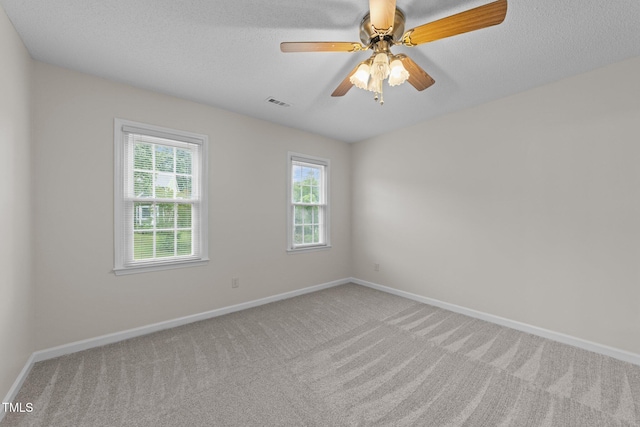 carpeted spare room with baseboards, a textured ceiling, and ceiling fan