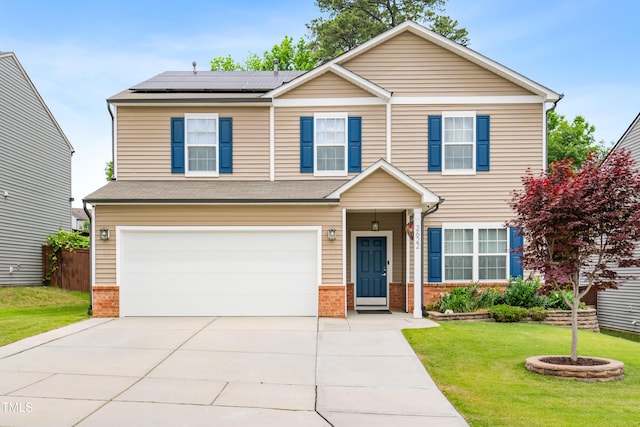 view of front of property featuring brick siding, solar panels, a garage, and a front yard