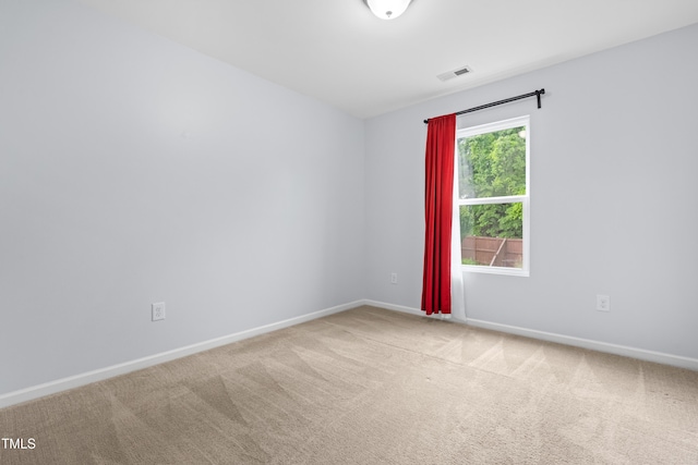 carpeted empty room featuring baseboards