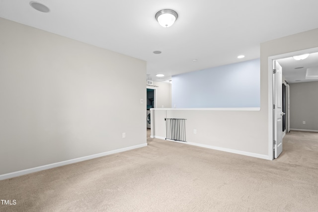 unfurnished room with light carpet and baseboards
