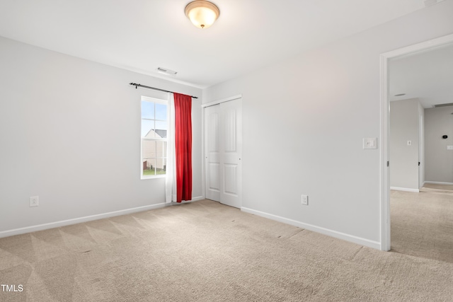 carpeted spare room featuring baseboards