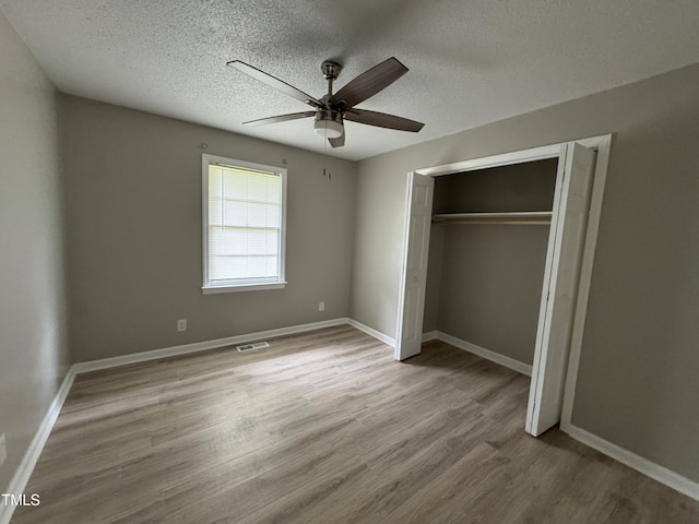 1064 Abbott Rd, Henderson, NC 27537 - unfurnished bedroom featuring wood finished floors, a textured ceiling, a closet, baseboards, and ceiling fan