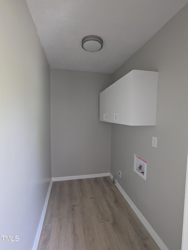 1064 Abbott Rd, Henderson, NC 27537 - clothes washing area featuring cabinet space, washer hookup, light wood-style floors, and baseboards