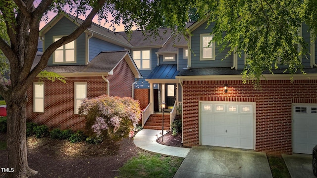 11013 Louson Pl, Raleigh, NC 27614 - view of front of home with brick siding, an attached garage, driveway, and roof with shingles