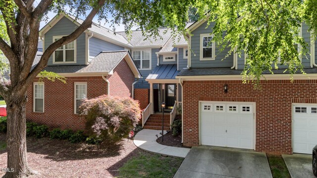 11013 Louson Pl, Raleigh, NC 27614 - view of front of house with brick siding, an attached garage, concrete driveway, and a shingled roof