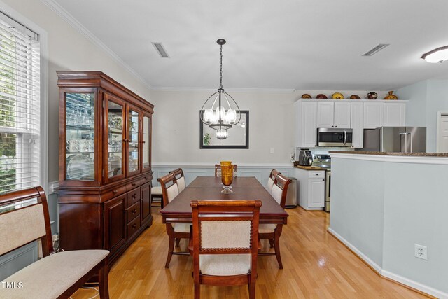 11013 Louson Pl, Raleigh, NC 27614 - dining area featuring light wood finished floors, a chandelier, and crown molding