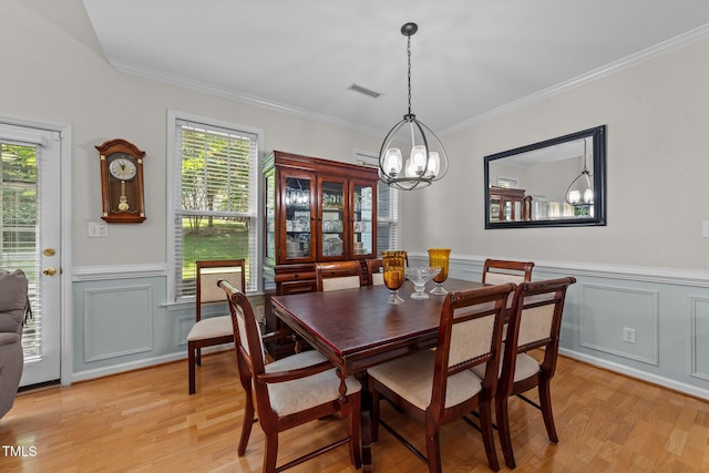 11013 Louson Pl, Raleigh, NC 27614 - dining area with light wood finished floors, a chandelier, plenty of natural light, crown molding, and wainscoting