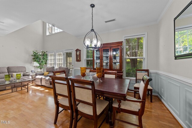 11013 Louson Pl, Raleigh, NC 27614 - dining area with healthy amount of natural light, a chandelier, a wainscoted wall, ornamental molding, and a decorative wall
