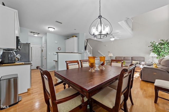 11013 Louson Pl, Raleigh, NC 27614 - dining room with light wood-style floors, a chandelier, stairway, and ceiling fan