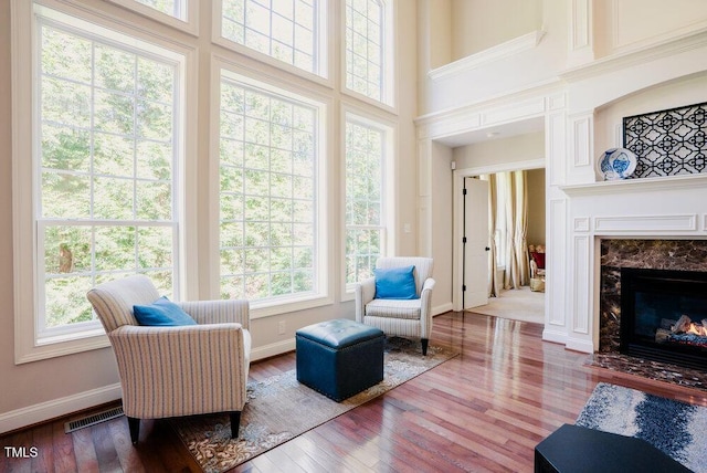 3911 Morvan Way, Raleigh, NC 27612 - sitting room with healthy amount of natural light, a high end fireplace, a towering ceiling, and wood finished floors