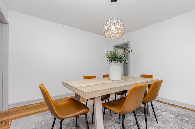 dining room with baseboards, light wood-style floors, and a chandelier
