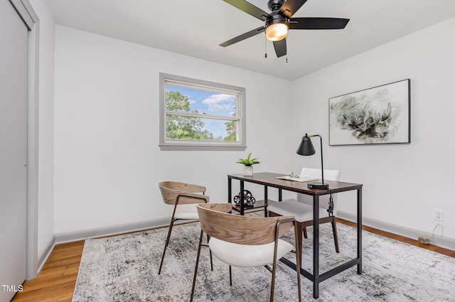 office with light wood finished floors, baseboards, and a ceiling fan