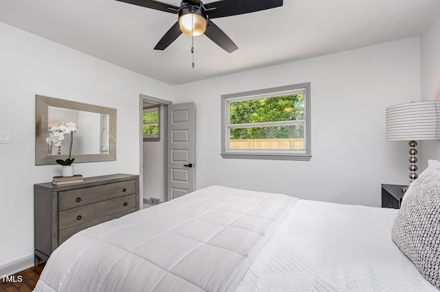 bedroom with dark wood-type flooring, baseboards, and a ceiling fan