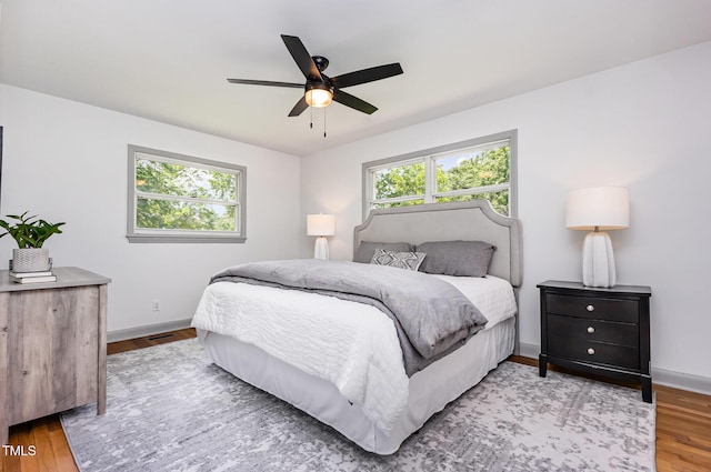 bedroom featuring wood finished floors, baseboards, and a ceiling fan