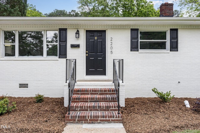 2205 W Carver St, Durham, NC 27705 - view of exterior entry featuring a chimney, brick siding, and crawl space