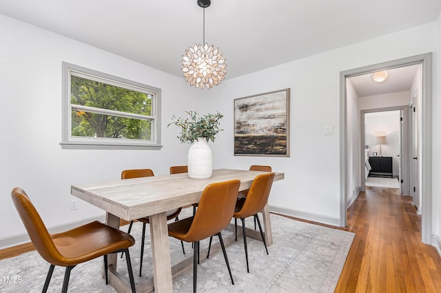 2205 W Carver St, Durham, NC 27705 - dining room with light wood-style flooring, baseboards, and a chandelier